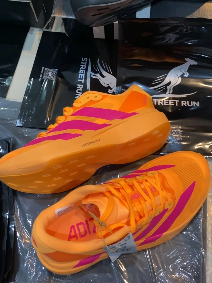 Adizero Adios Pro 4 laranja e rosa, ângulo 1 de 4
